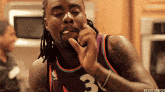 a man wearing a jersey with the number 3 on it is smoking a cigarette