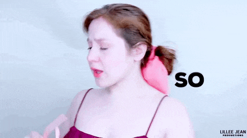 a woman is holding a pair of pink sunglasses and crying while looking at them .