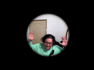 a person in a green sweater is waving their hand