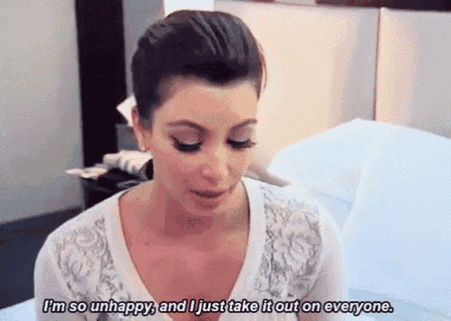 a woman is sitting on a bed and says i 'm so unhappy and i just take it out on everyone
