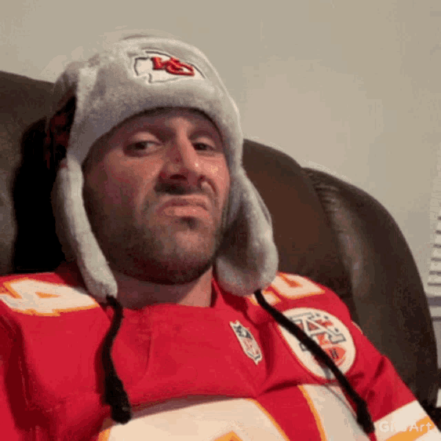 a man wearing a kansas city chiefs hat and jersey