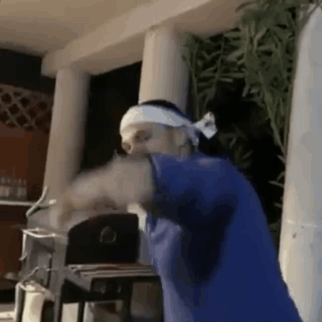 a man wearing a headband is dancing on a porch .