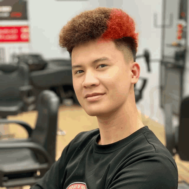 a young man with red hair is wearing a black shirt that says " play of the world "
