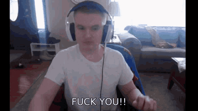 a man wearing headphones says " fuck you " in front of a couch