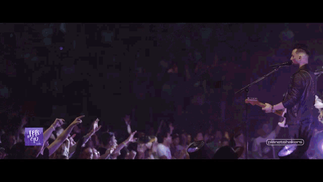 a woman singing into a microphone with the words let 's go on the bottom left