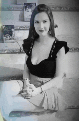 a woman in a black top sits on the floor