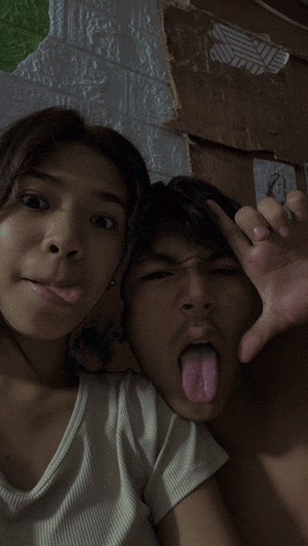 a man and a woman sticking out their tongues