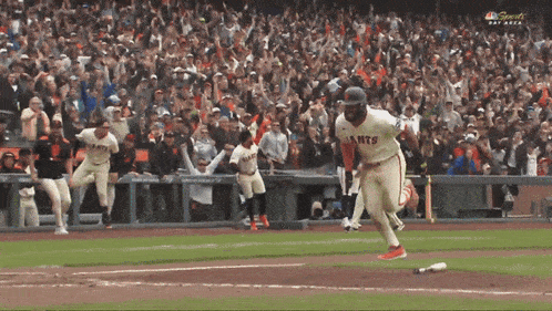 a baseball player wearing a giants jersey is running on the field