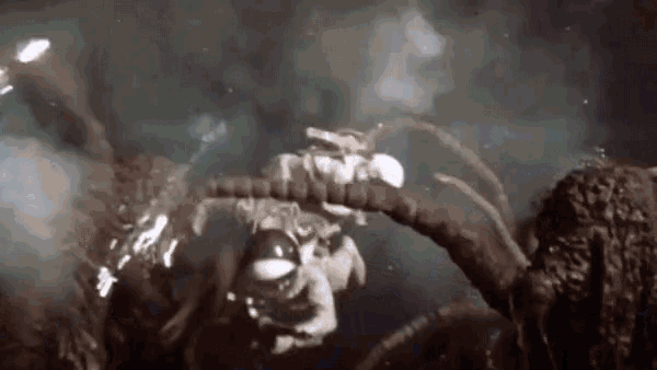 a man in a space suit is being attacked by a giant monster .