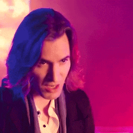 a man with long blue hair is wearing a tuxedo