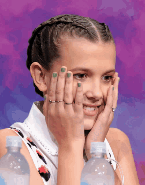 a girl with green nail polish and rings on her fingers