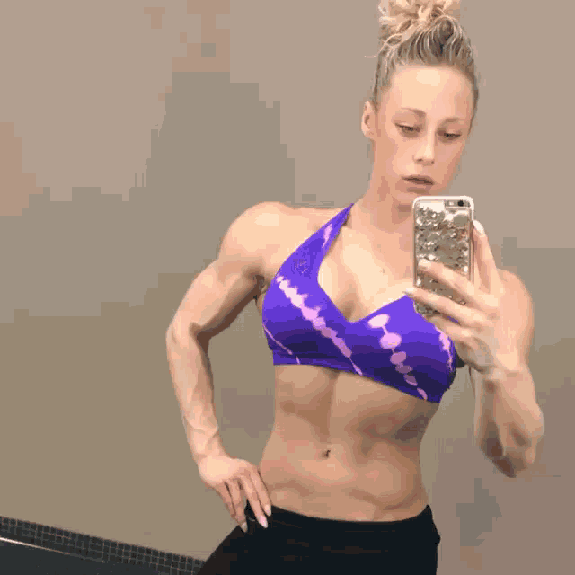 a woman taking a picture of herself in a bathroom mirror