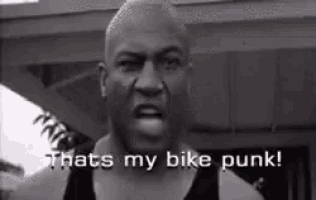 a black and white photo of a man saying `` that 's my bike punk '' .