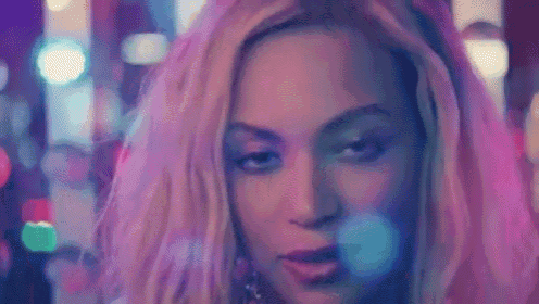 a close up of a woman 's face with purple and blue lights in the background