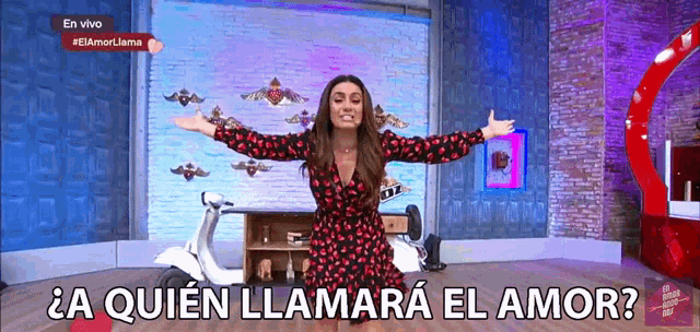 a woman in a red and black dress is standing in front of a motorcycle and a sign that says en vivo #elamorjama