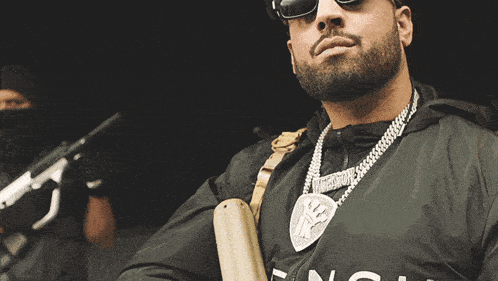 a man with a beard wearing sunglasses and a black hat