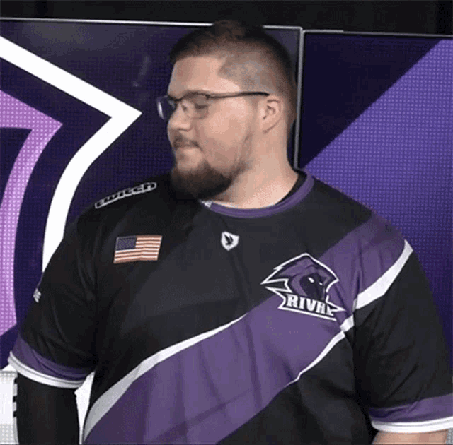 a man wearing glasses and a purple shirt that says rival on it