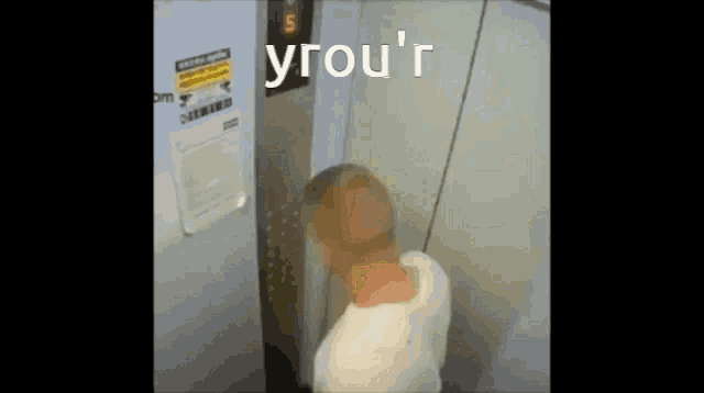 a man in an elevator with the word yrou 'r above him