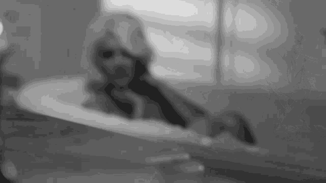 a black and white photo of a woman taking a bath in a bathtub .