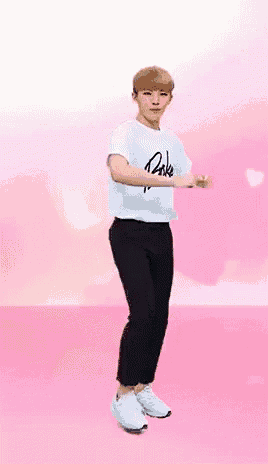 a young man is dancing on a pink background .