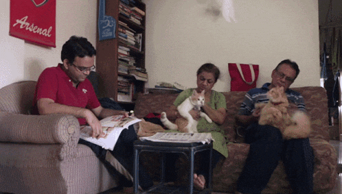 a man in a red shirt is reading a magazine