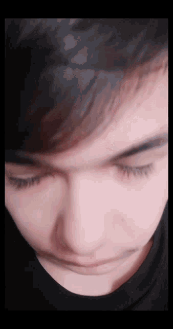 a close up of a person 's eyes with a black shirt on