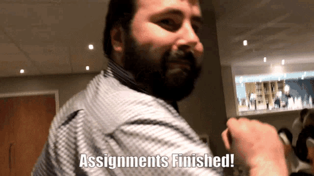 a man with a beard says " assignments finished " in a room