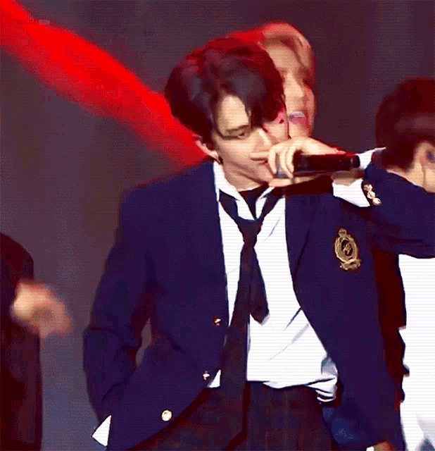 a man in a suit and tie holds a microphone in his hand