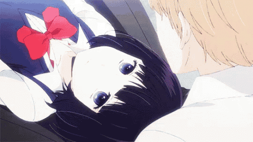 a girl with a red bow on her head is laying on a man 's lap