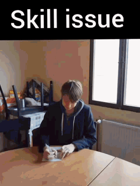 a man sits at a table with the words skill issue written on the bottom