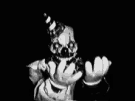 a black and white photo of a creepy clown with a party hat on .