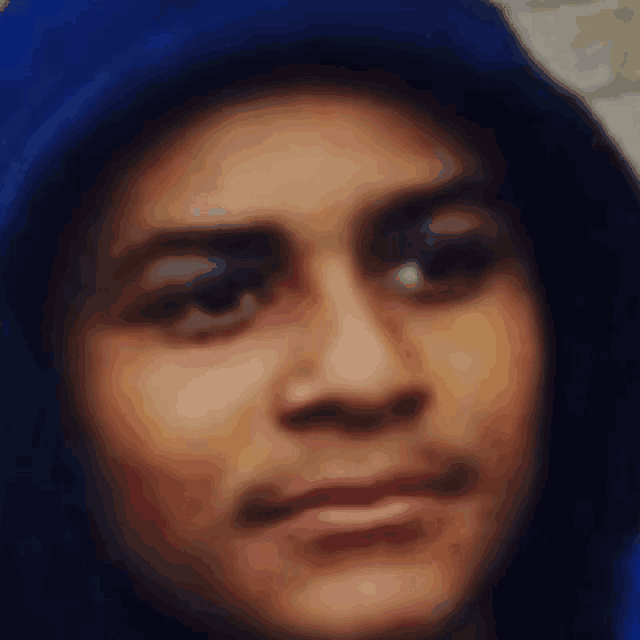 a blurry picture of a person wearing a blue hooded jacket