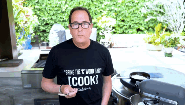 a man wearing a black t-shirt that says " bring the " c " word back "