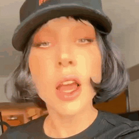 a close up of a person wearing a baseball cap and wig .