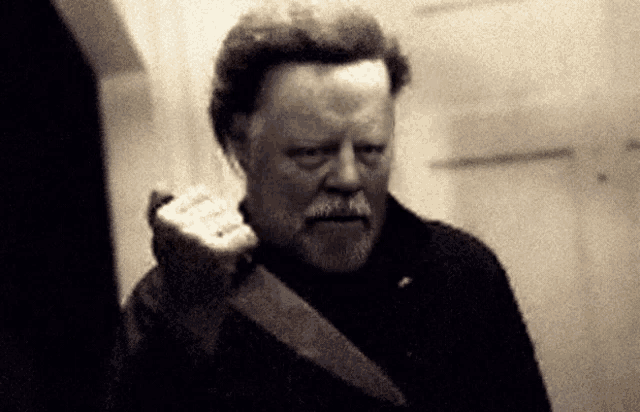 a man with a beard is holding a knife in his right hand