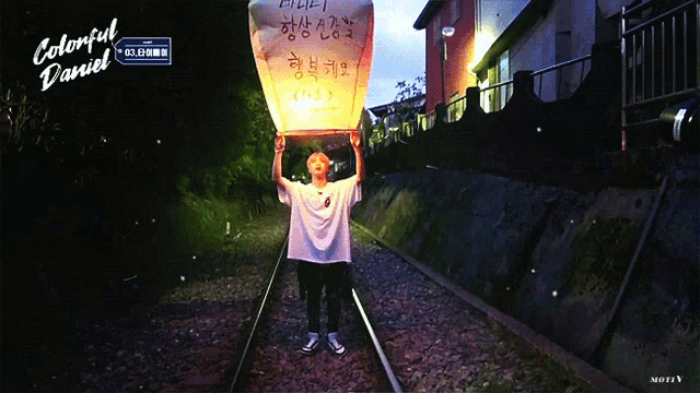 a person holding a lantern that says ' colorful daniel ' on the bottom