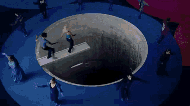a man is holding a woman 's hand while she is laying in a tunnel .