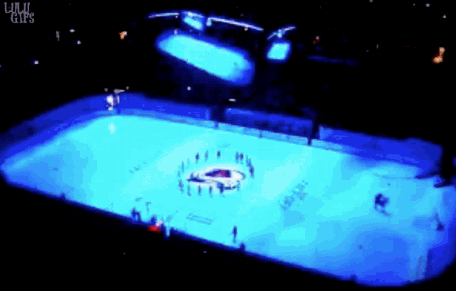 a hockey rink is lit up with blue lights and the words lulu girl 's are on the bottom