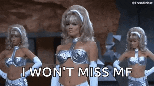 a woman in a silver bra and gloves is standing next to two other women in silver costumes .