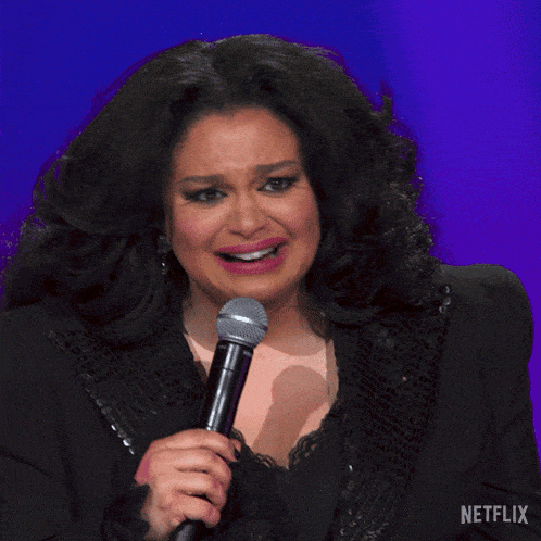 a woman singing into a microphone with a netflix logo in the background