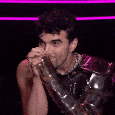a man with a beard is wearing armor and a necklace .