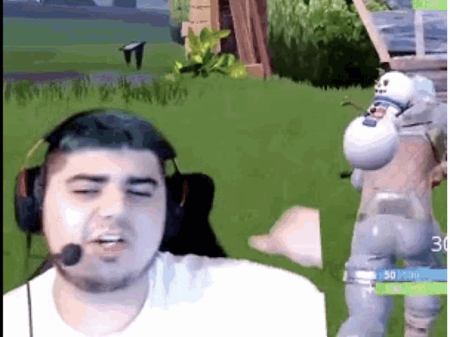 a man wearing headphones and a microphone is playing a video game with a snowman in the background .