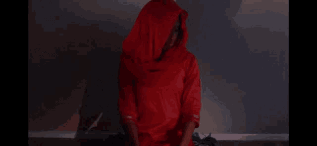 a woman in a red hoodie is sitting on the floor .