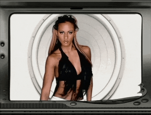 a woman in a black top is standing in front of a white circle on a tv screen