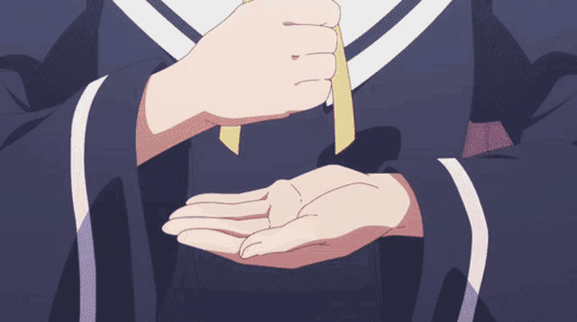 a close up of a person 's hands with a yellow ribbon