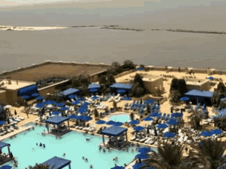 a large swimming pool surrounded by blue umbrellas