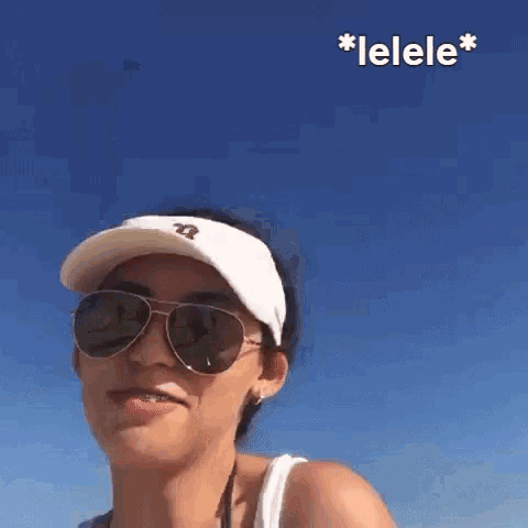 a woman wearing sunglasses , a hat and a visor .