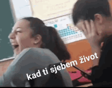 a man and a woman are laughing in a classroom with the words kad ti sjebem zivot written on the bottom