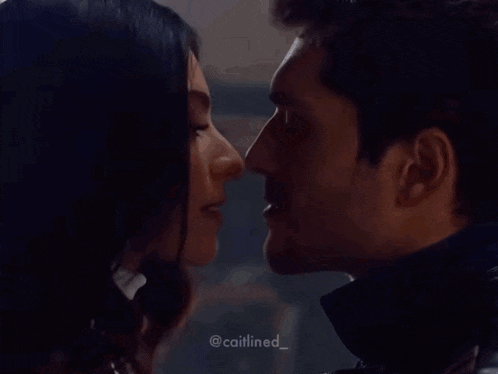 a man and a woman are kissing in a dark room