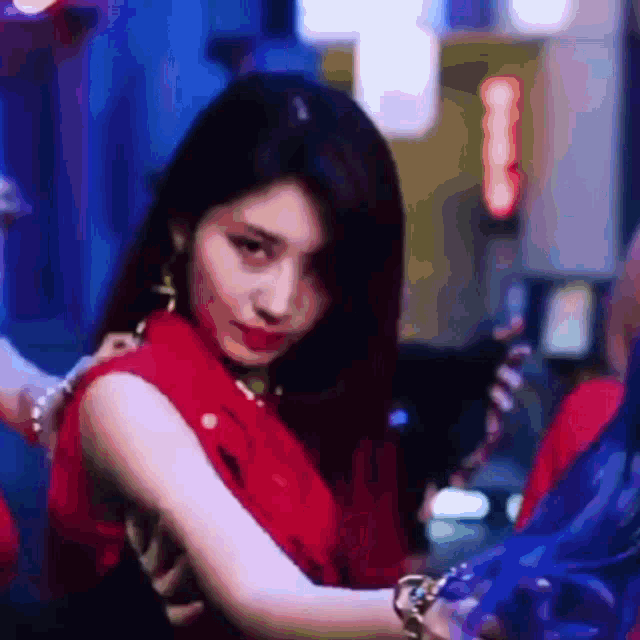 a woman in a red dress is looking at the camera in a blurry photo